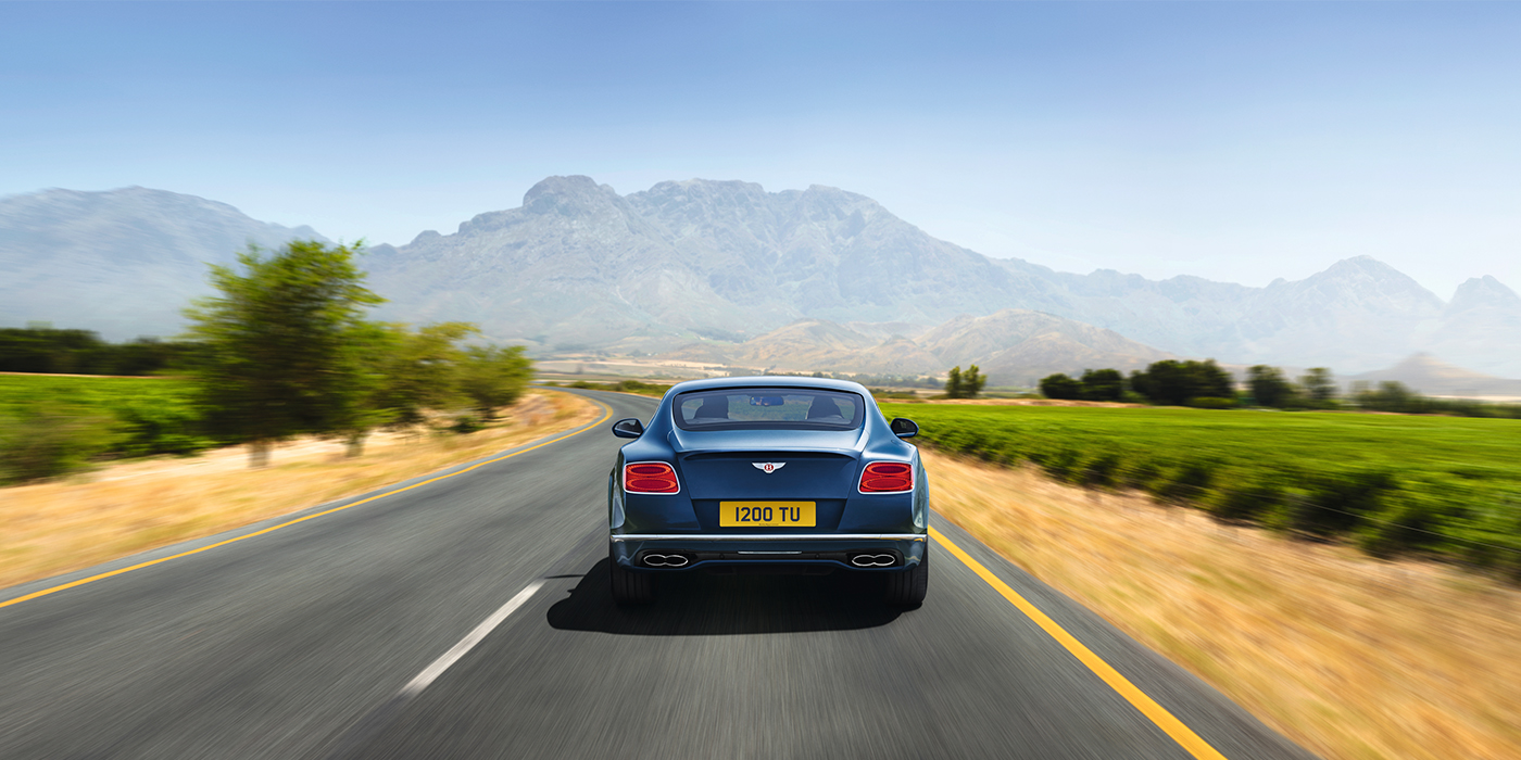 Bentley Luxembourg Bentley Pre Owned Bentley Continental GT in Marlin blue paint seen from rear on country road