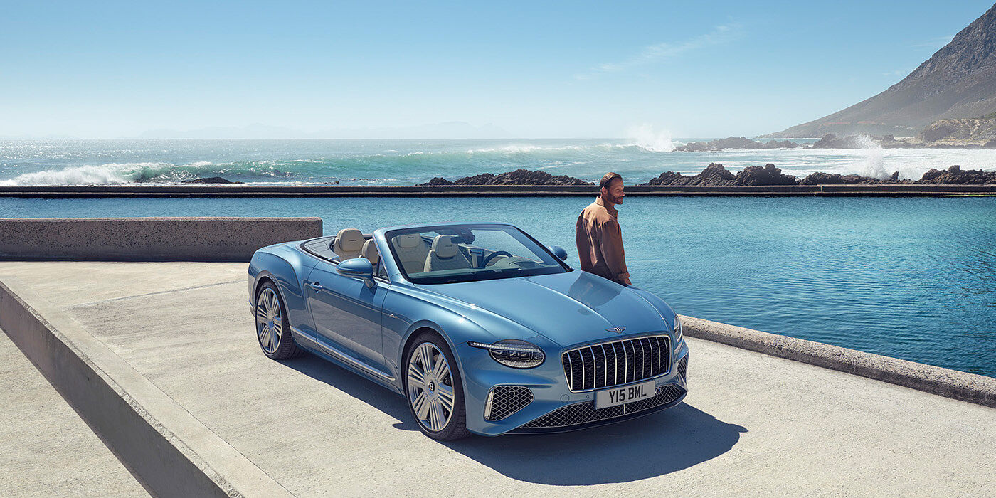 Bentley Luxembourg New Bentley Continental GTC Azure convertible front view in Light Windsor blue paint with 22 inch ten spoke wheels parked by the sea in the sunshine