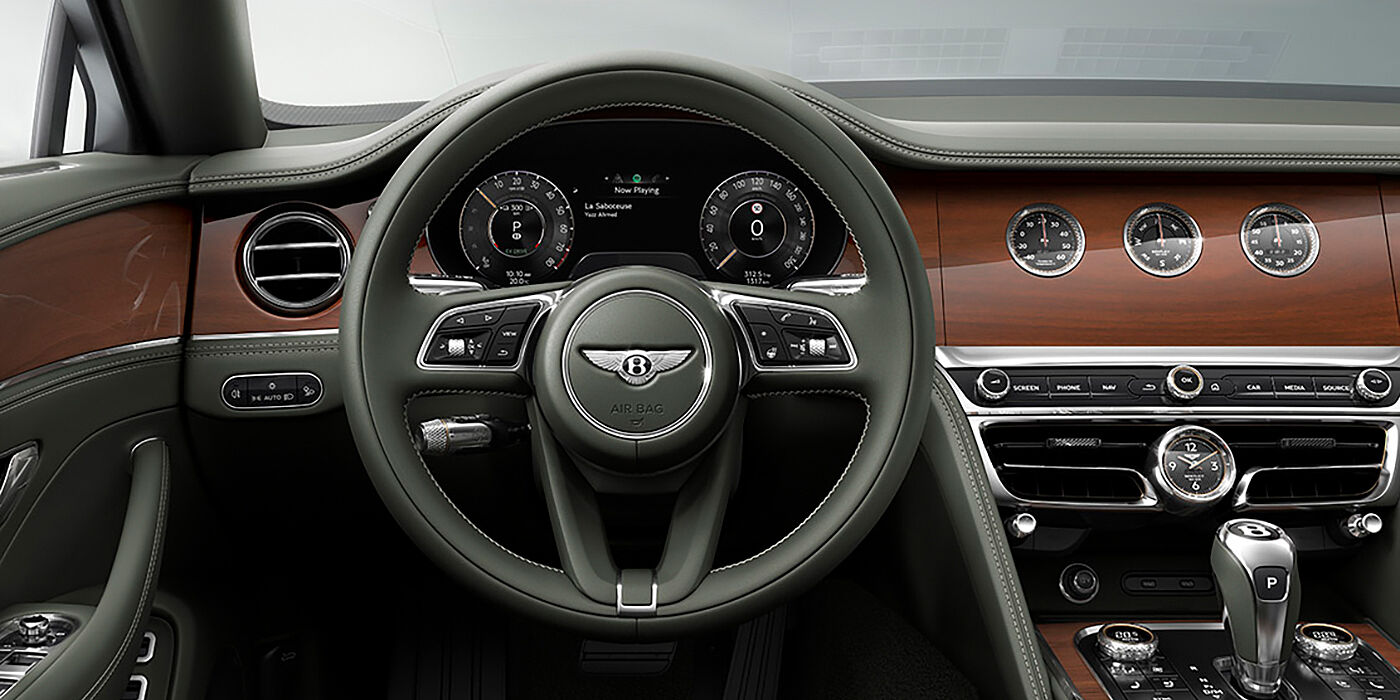 Bentley Luxembourg New Bentley Flying Spur sedan front cabin in Cumbrian Green hide and Crown Cut walnut veneer showing steering wheel and Rotating Display with three clocks on face