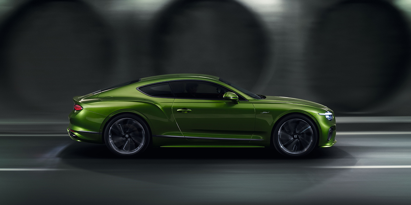Bentley Luxembourg Bentley Continental GT coupe in Tourmaline Green paint driving in profile on a dark road